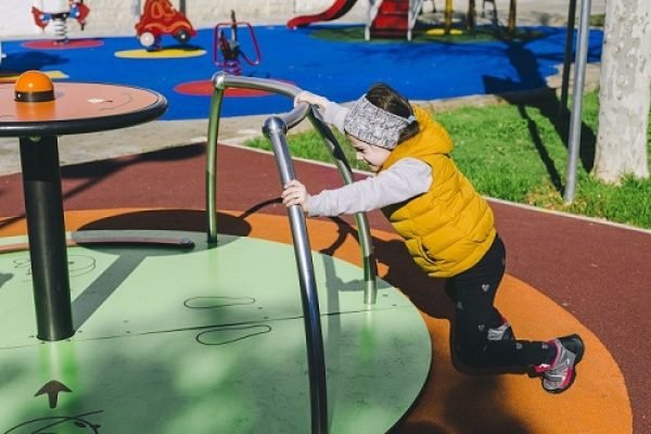 girl-pushing-roundabout-park